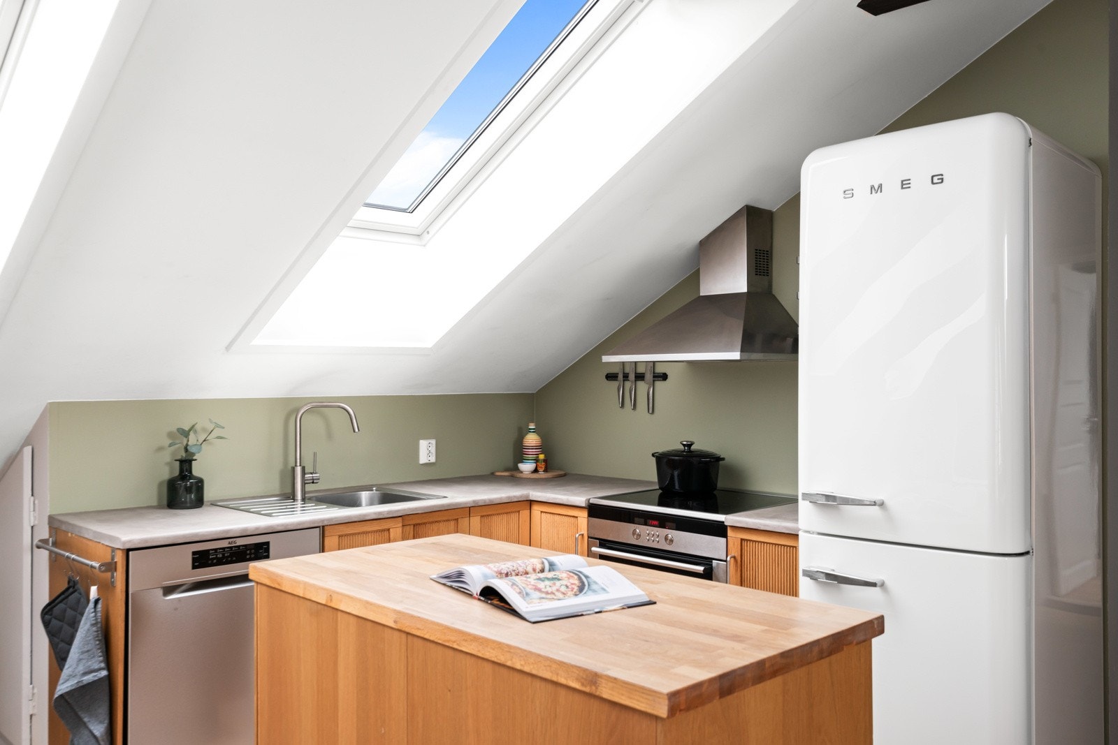 Kjøkkenet er stilrent og funksjonelt, hvor en nyere innredning har profilerte eikefronter og oppvaskkum nedfelt i en benkeplate med mikrosement. Galleribilde