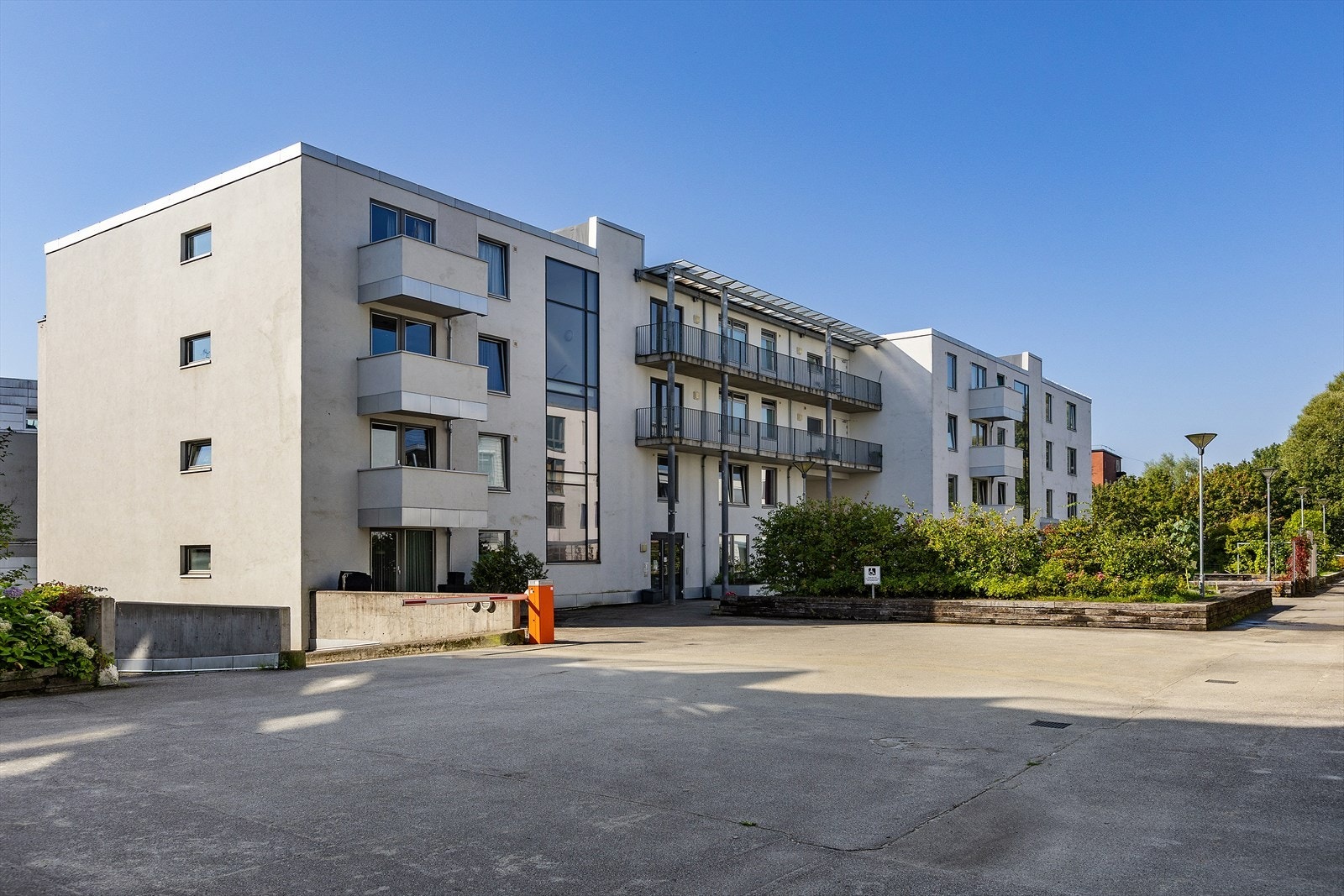 Felles tomt for borettslaget opparbeidet med asfalterte internveier, prydbusker og diverse beplantning. Galleribilde