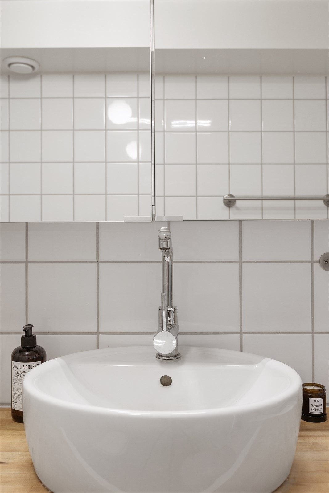 Glatt baderomsinnredning med servant og speilskap med belysning over. Galleribilde