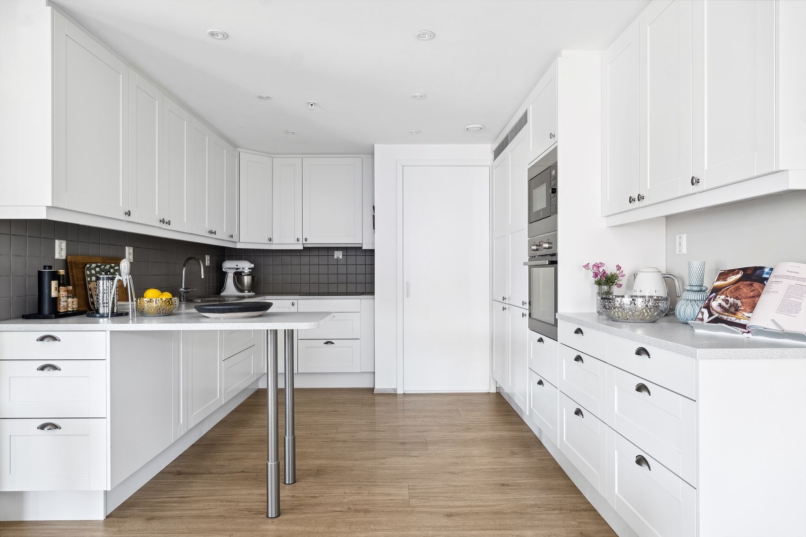 Tidløst kjøkken som inviterer til matlaging. Integrerte hvitevarer. Separat kjøl/frys i langskap. Galleribilde