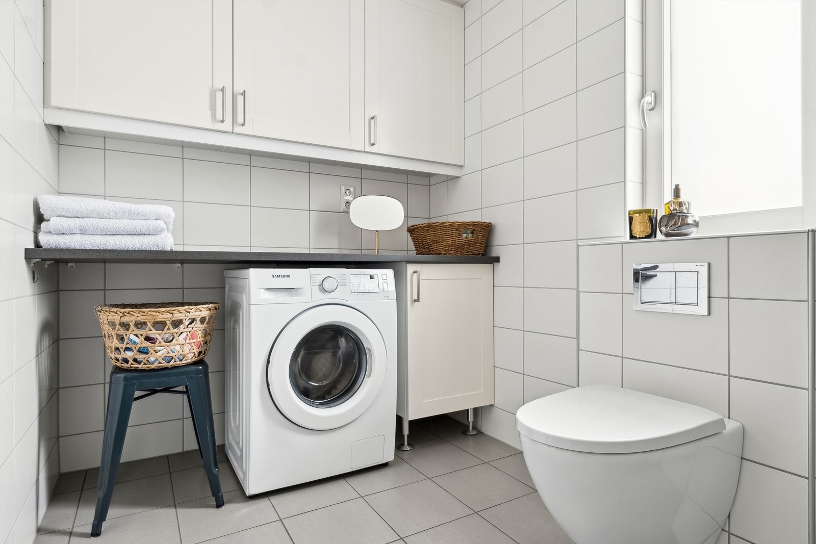 Innreding med overskap og plass til vaskemaskin og tørketrommel under benk. Dette er en svært praktisk løsning. Galleribilde