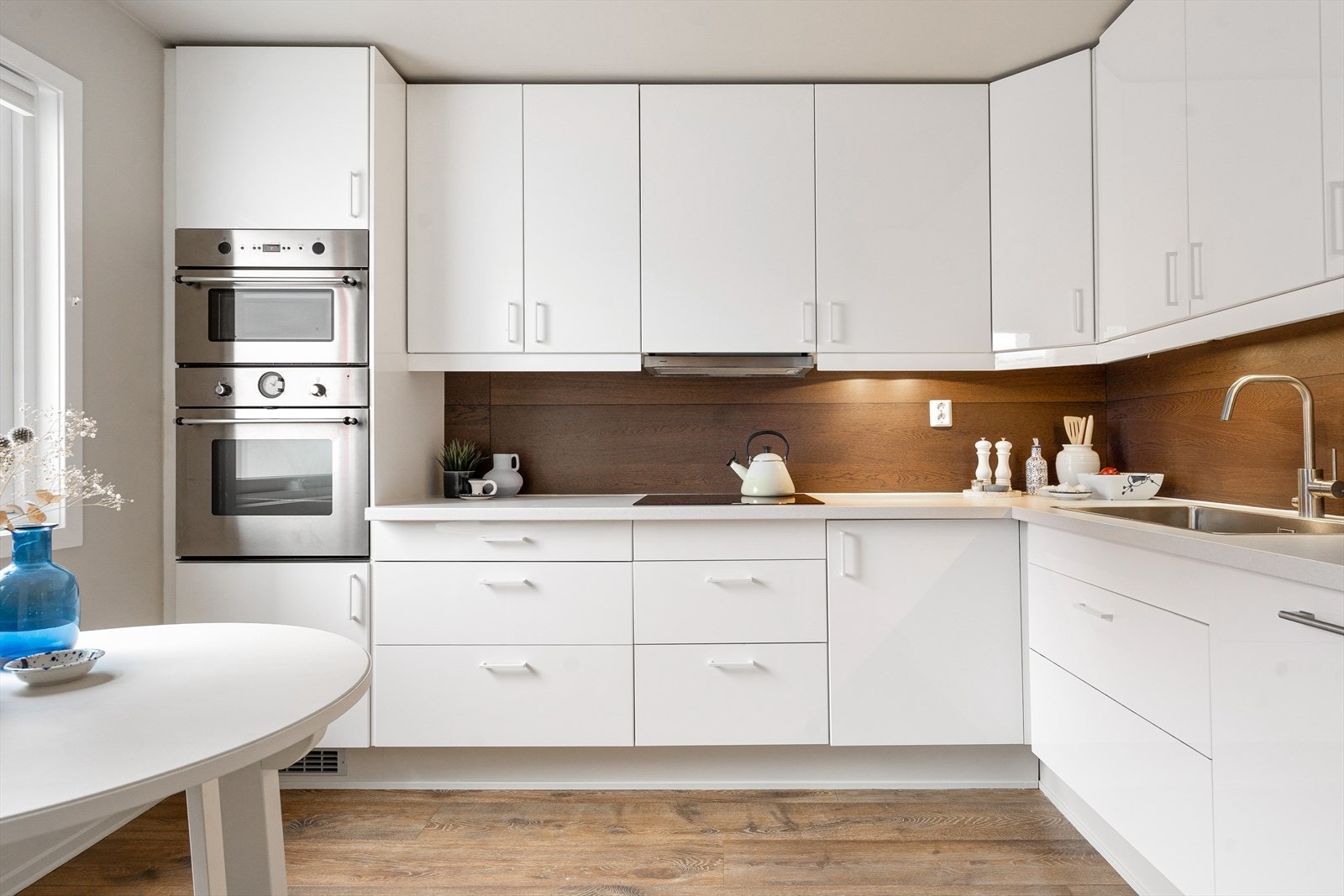 Lys og smakfull innredning med glatte fronter og benkeplate i laminat. Galleribilde