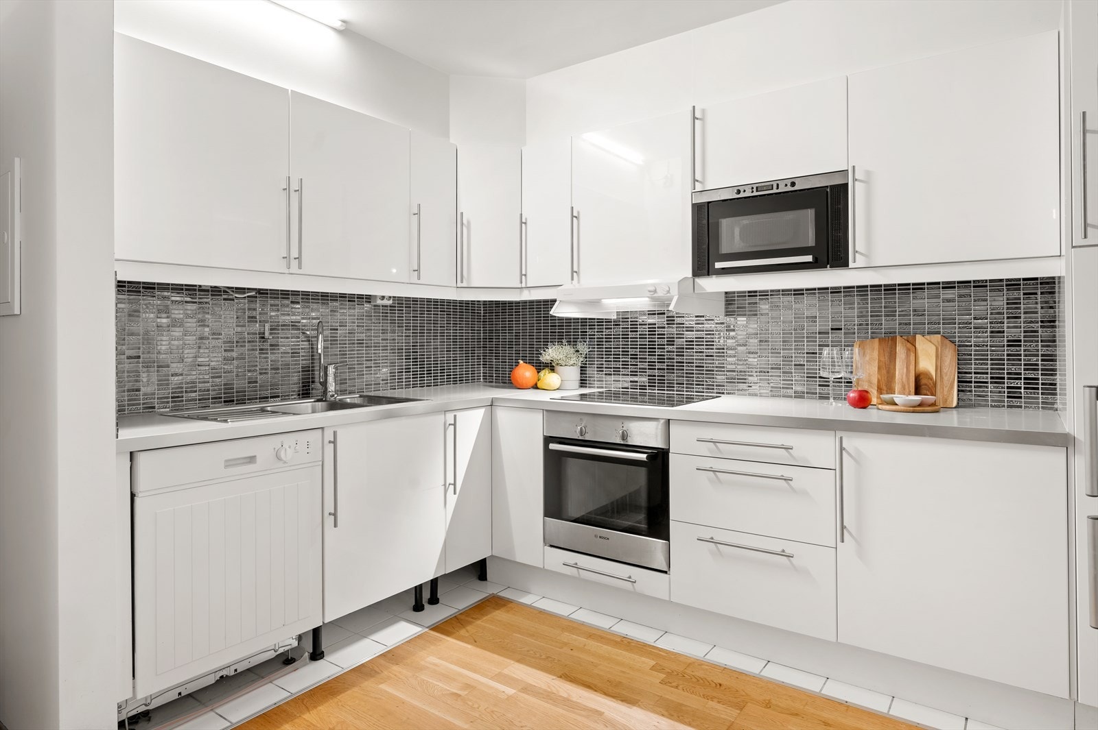 Lyst og velholdt kjøkken med glatte fronter og laminat benkeplate. Galleribilde