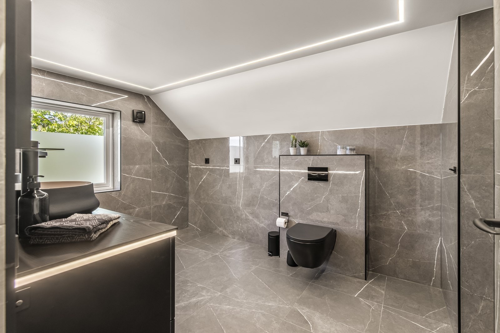 Badet fra 2023 har råstilige fliser på både gulv og vegger. Galleribilde