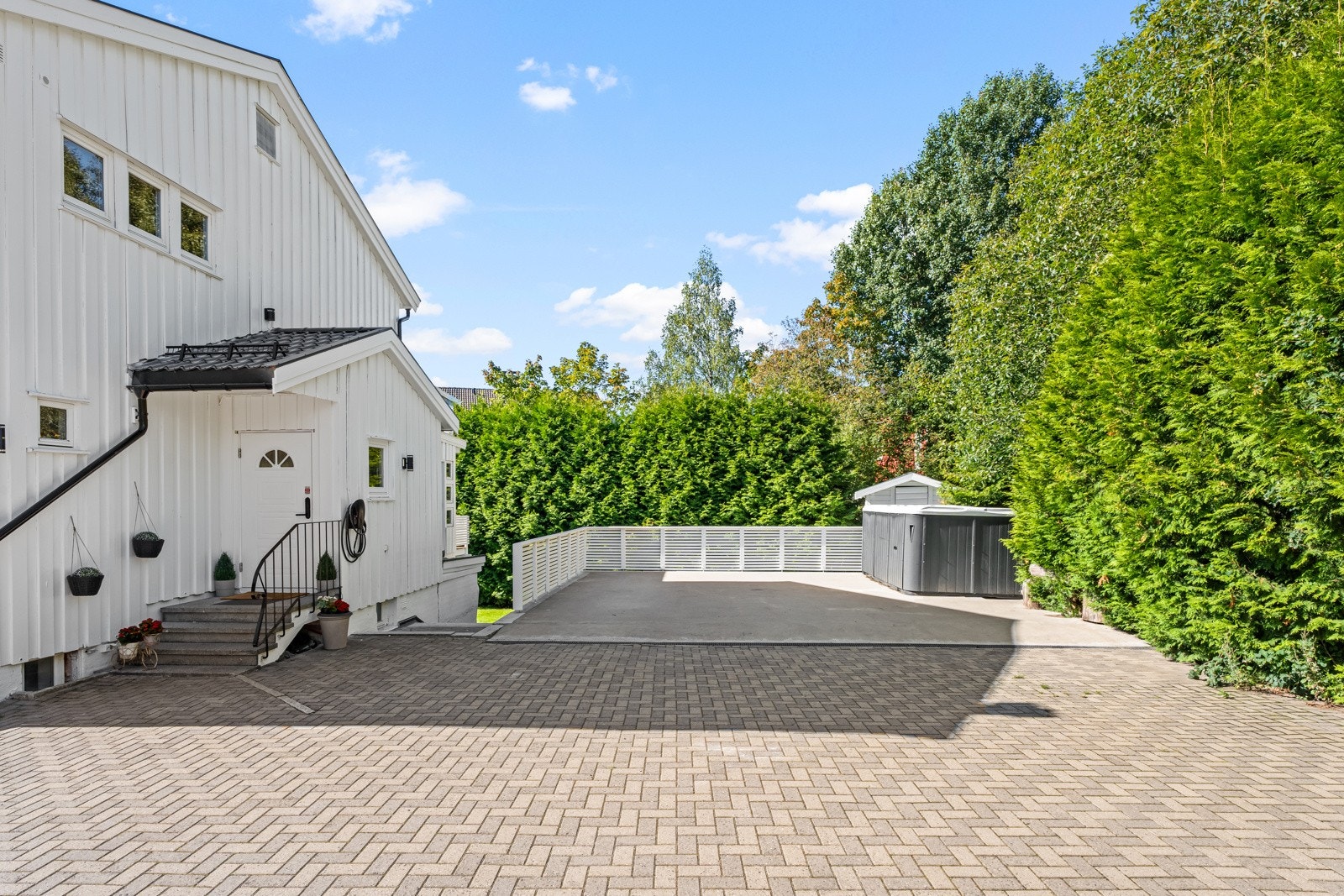 Det er parkering på steinsatt og støpt gårdsplass. Galleribilde