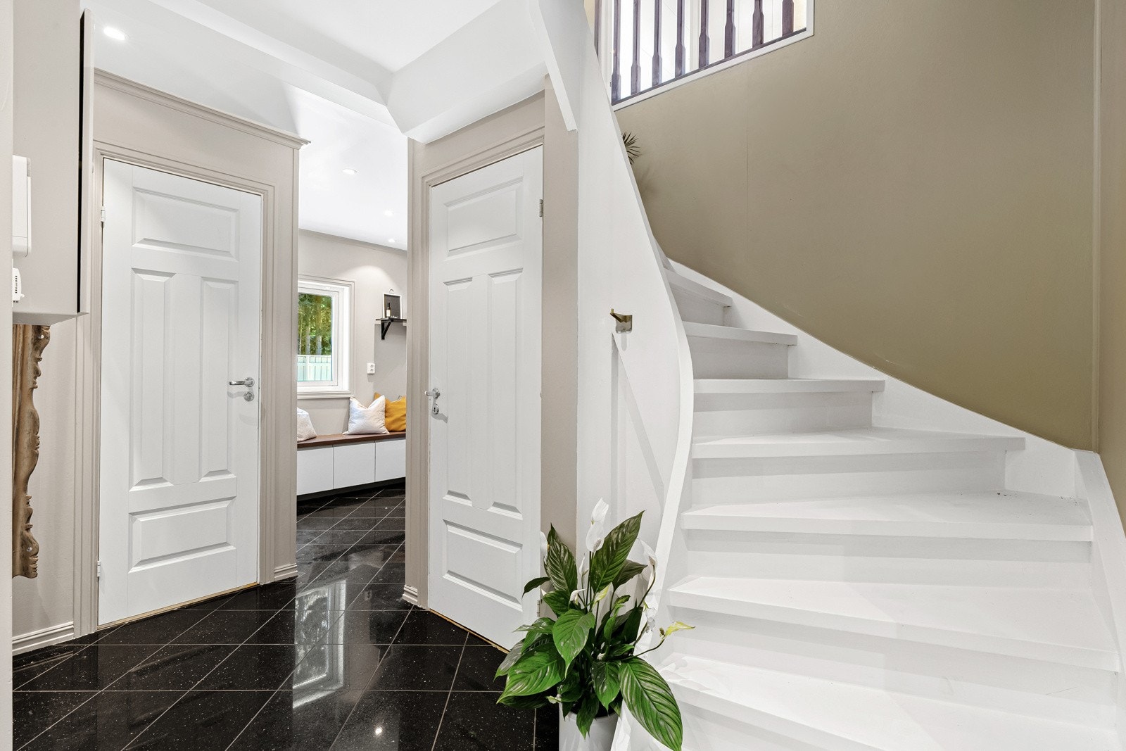 Entreen ligger åpen mot trapperommet, hvor det er hvitmalt trapp opp til andre etasje, samt dør inn til gjestetoalett og direkte adkomst til stue og kjøkken. Galleribilde