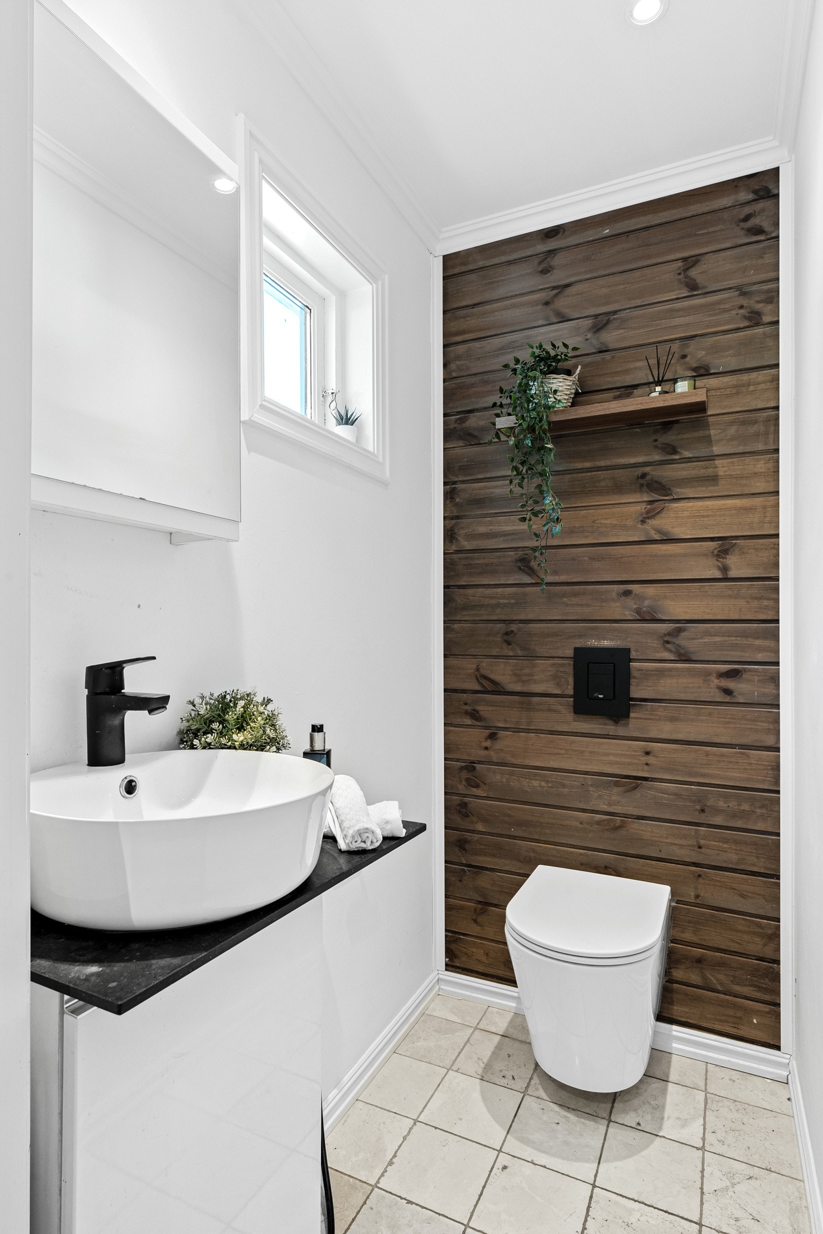 Toalettrommet i første etasje ble pusset opp i 2017, og har beige gulvfliser, slette veggflater og en endevegg kledd i mørkbeiset panel. Galleribilde