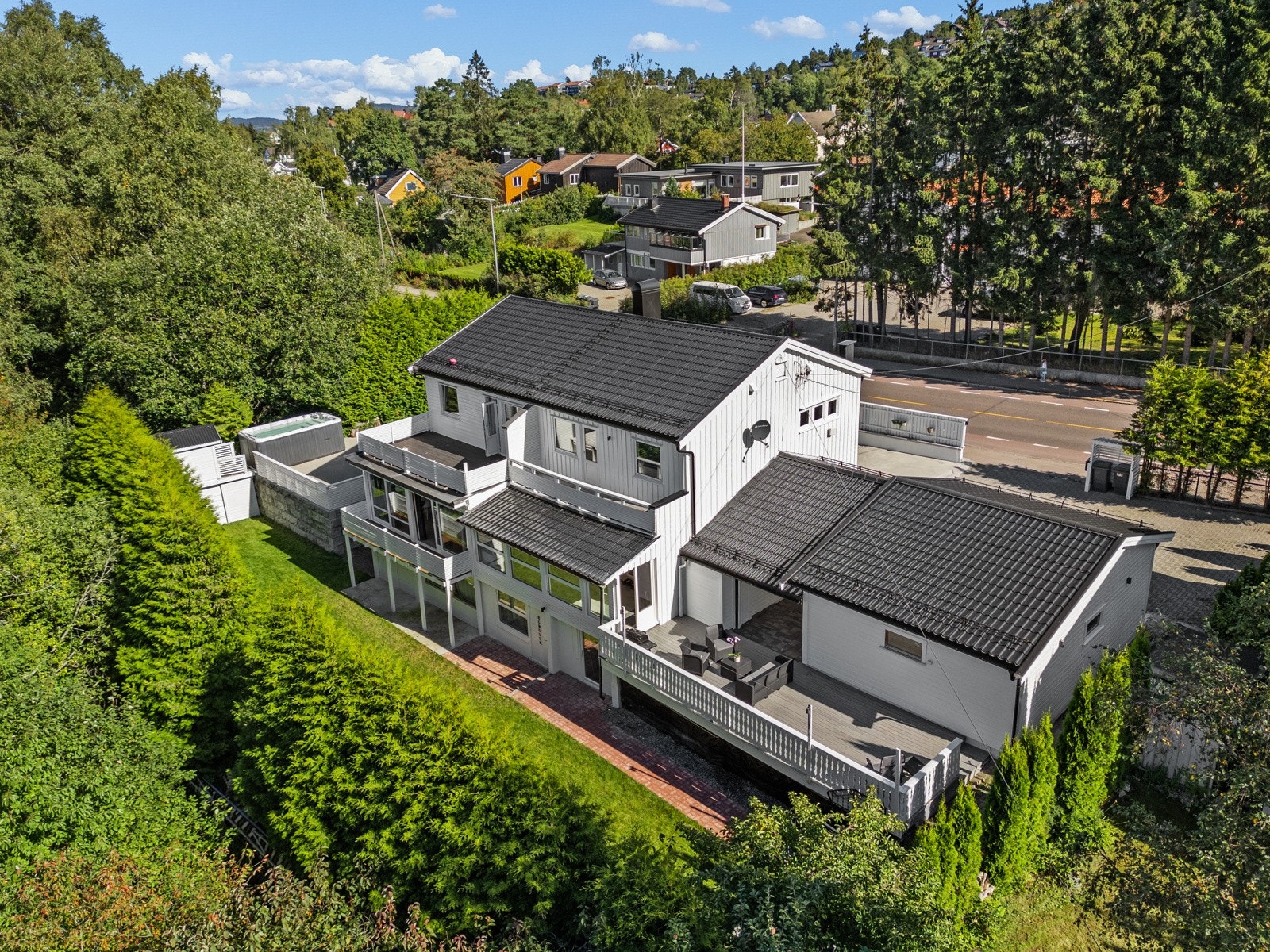 Boligen oppleves som skjermet med den grønne, høye hekken på utsiden. Galleribilde