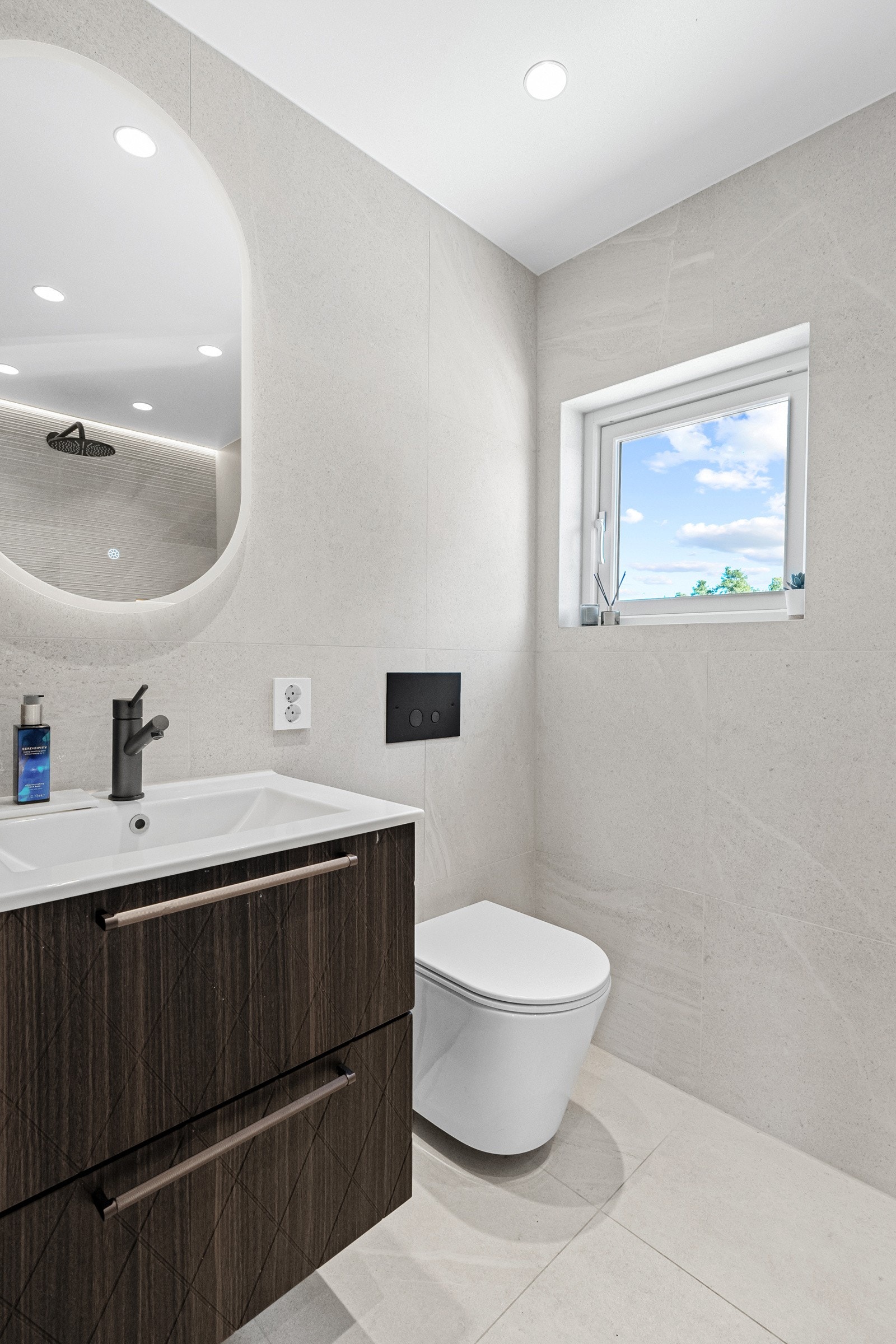 Vegger og gulv er belagt med lysegrå fliser, det er varmekabler i gulvet, downlights i himling og et vindu på endeveggen som gir ekstra med naturlig lys. Galleribilde