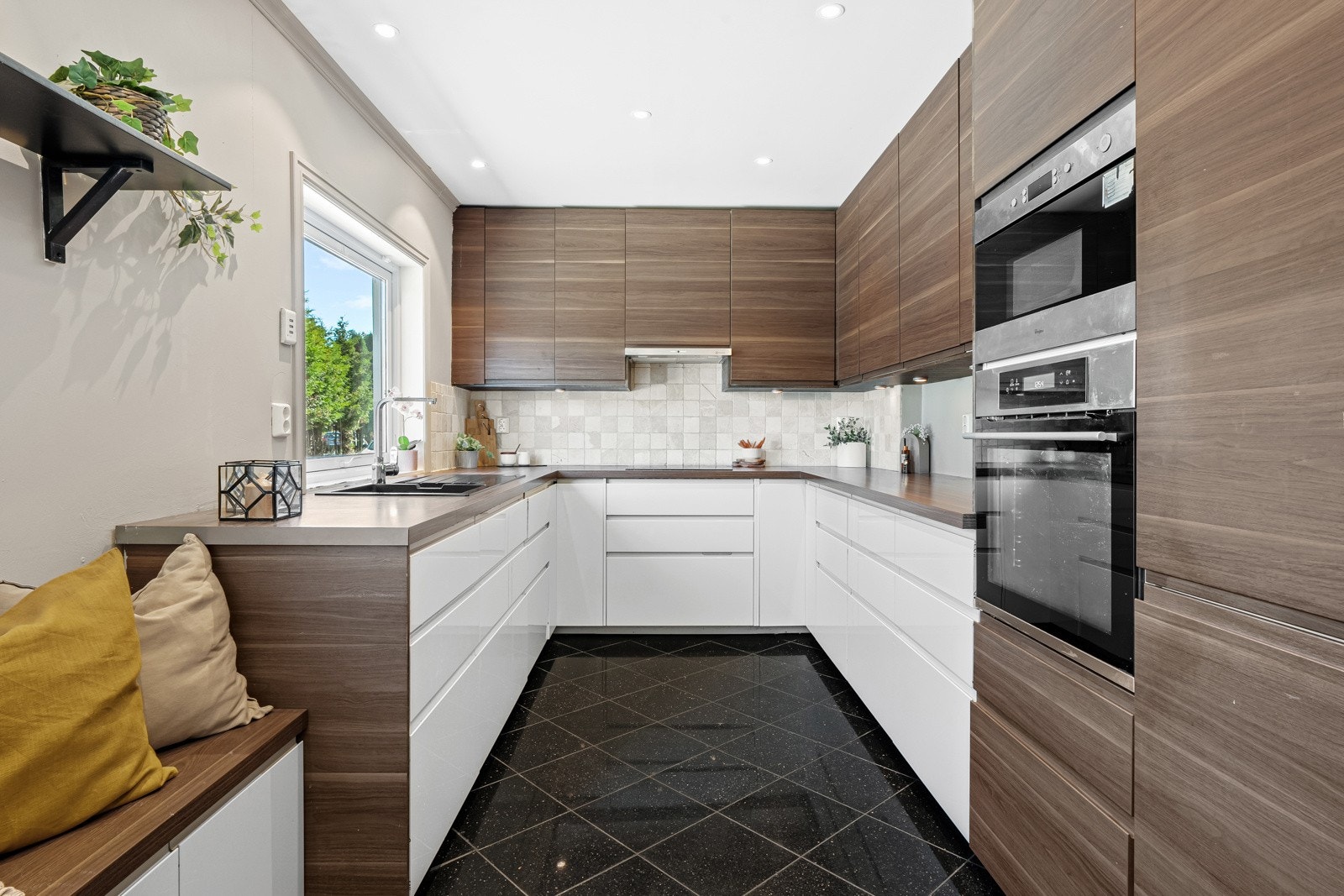 Innredningen har takhøye veggskap og høyskap med glatte, valnøttfargede fronter, freste grep, samt matchende dekksider og benkeplate. Galleribilde