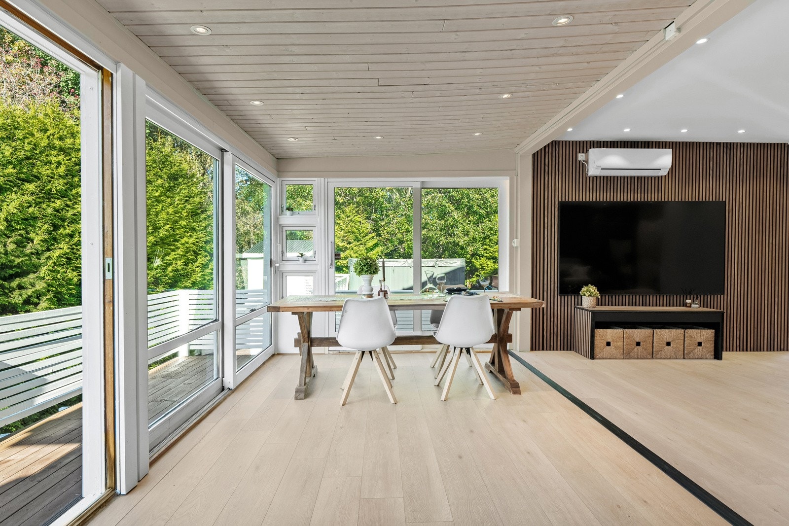 Trendy spilevegg bak TV-en skaper dybde og tekstur i rommet. Integrert varmepumpe på veggen sikrer behagelig temperatur året rundt. Galleribilde