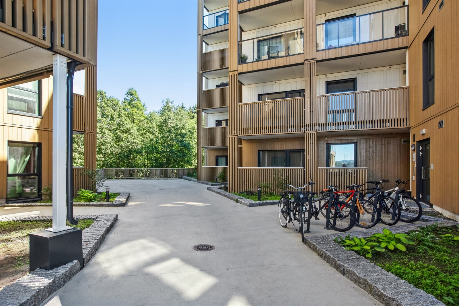 Stilrene fellesarealer opparbeidet med gangarealer, plenareal, prydbusker og diverse beplantninger. Galleribilde