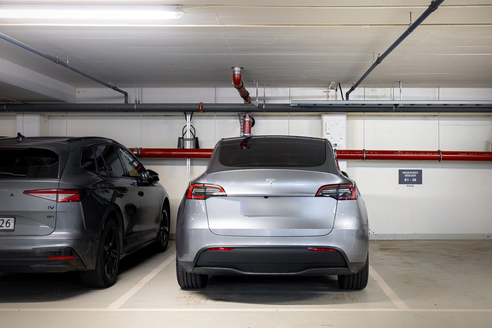 Garasjeplass med elbillader i felles garasjekjeller. Galleribilde