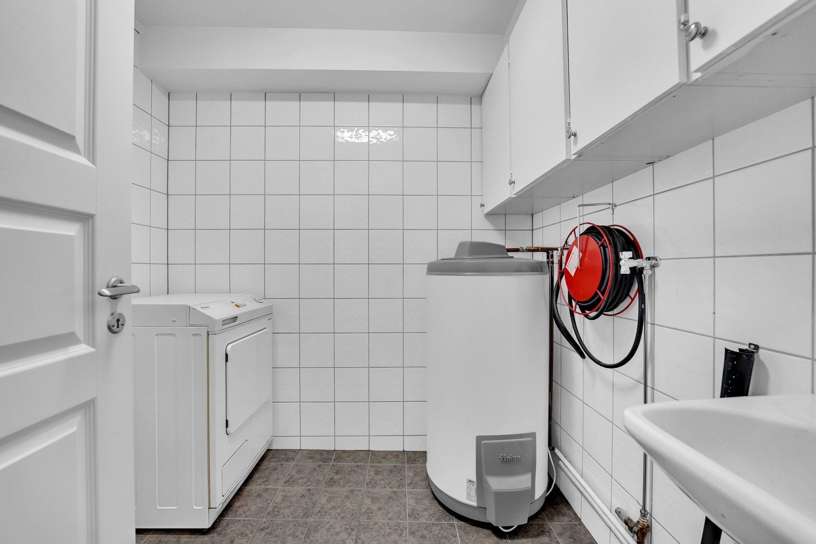 Praktisk vaskerom med flere veggskap, servant, v.v.bereder og opplegg for vaskemaskin. Galleribilde