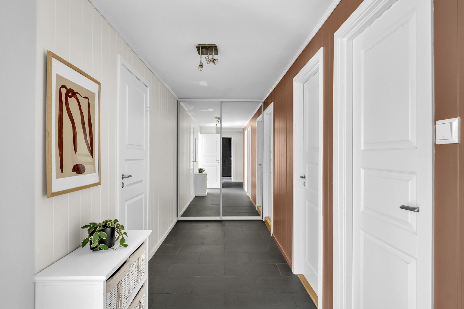 I enden av gangen er det montert en skyvedørsgarderobe med speilfronter, som har god plass til yttertøy, sko og utstyr. Galleribilde