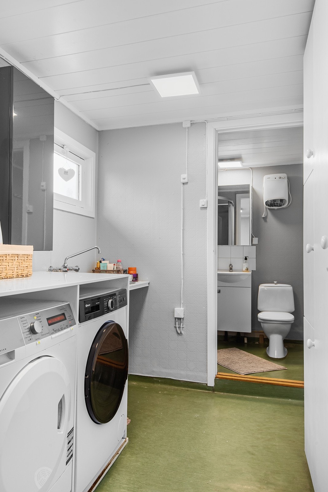 Vaskerommet er innredet med løsning for vaskemaskin og tørketrommel med benk over og utslagskum, samt vegghengt skap og garderobeskap. Galleribilde