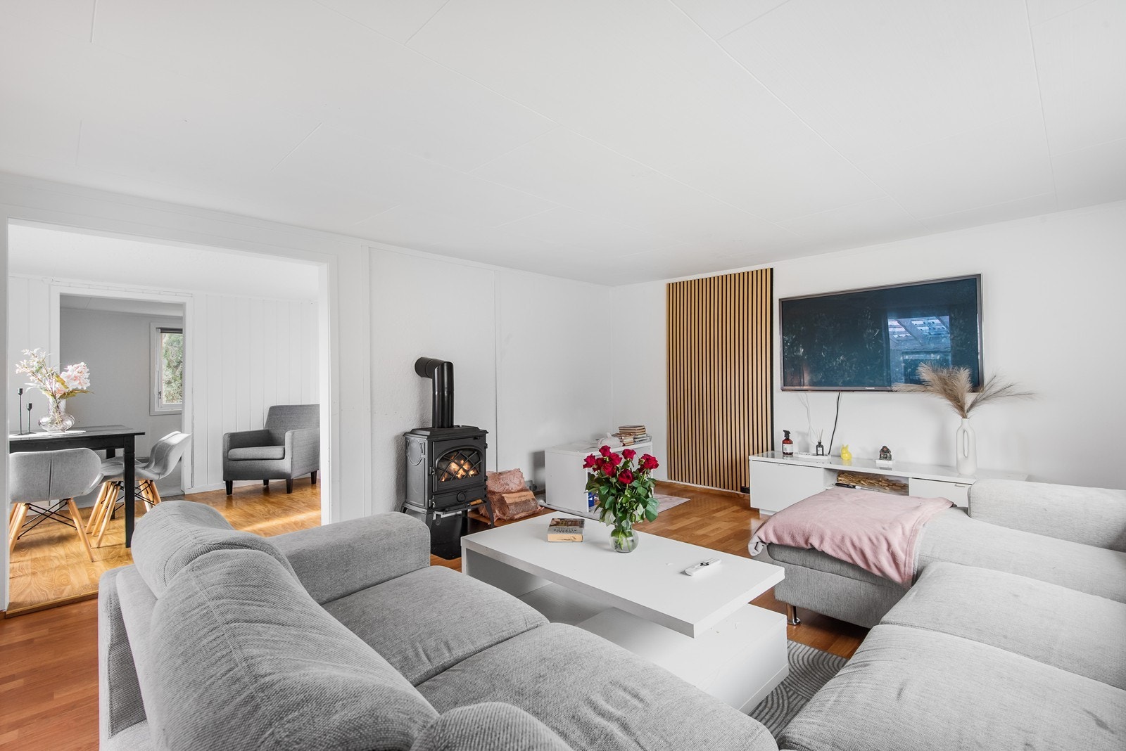 Boligen har en romslig stue som fremstår lys og åpen med store vindusflater. Midt i rommet står en peisovn for hygge og ikke minst varme på kalde dager. Galleribilde