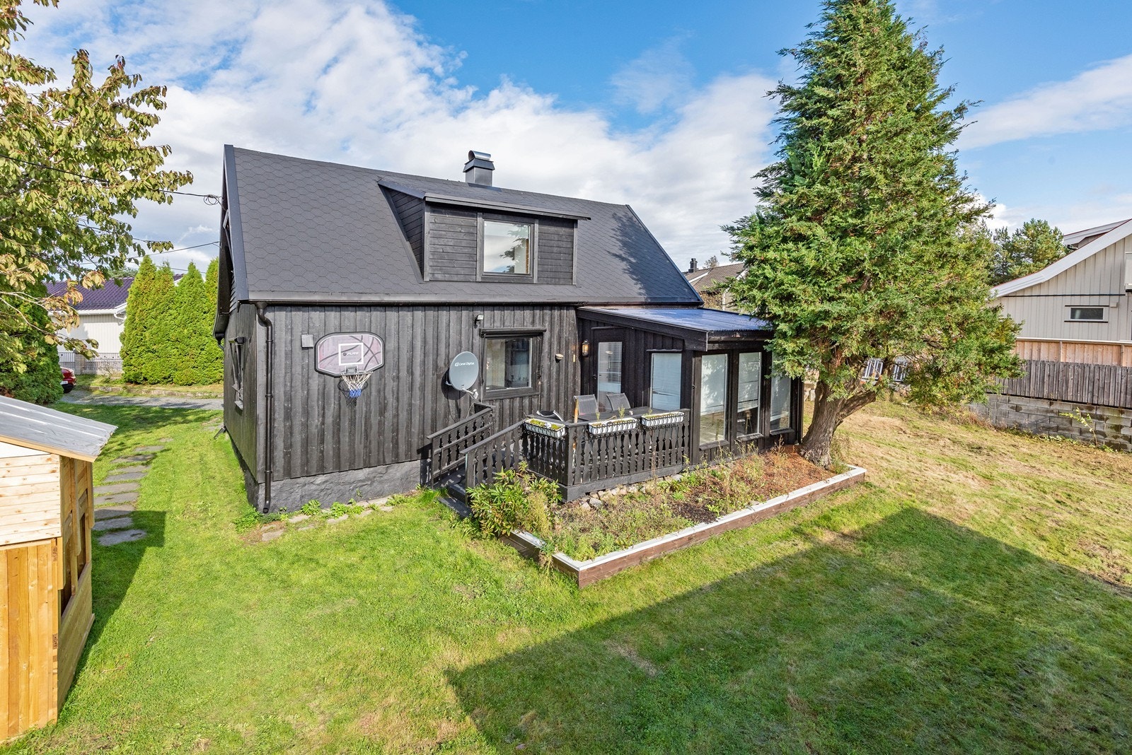 Veranda har plass til møblement og videre trapp ned til hage med gressplen. Galleribilde