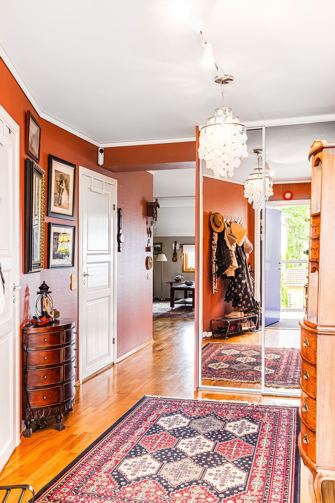 Du ønskes velkommen inn i en praktisk entré som er malt i fargen Welcome red i 2023. God oppbevaringsplass i stor plassbygget skyvedørsgarderobe med speildører. Galleribilde