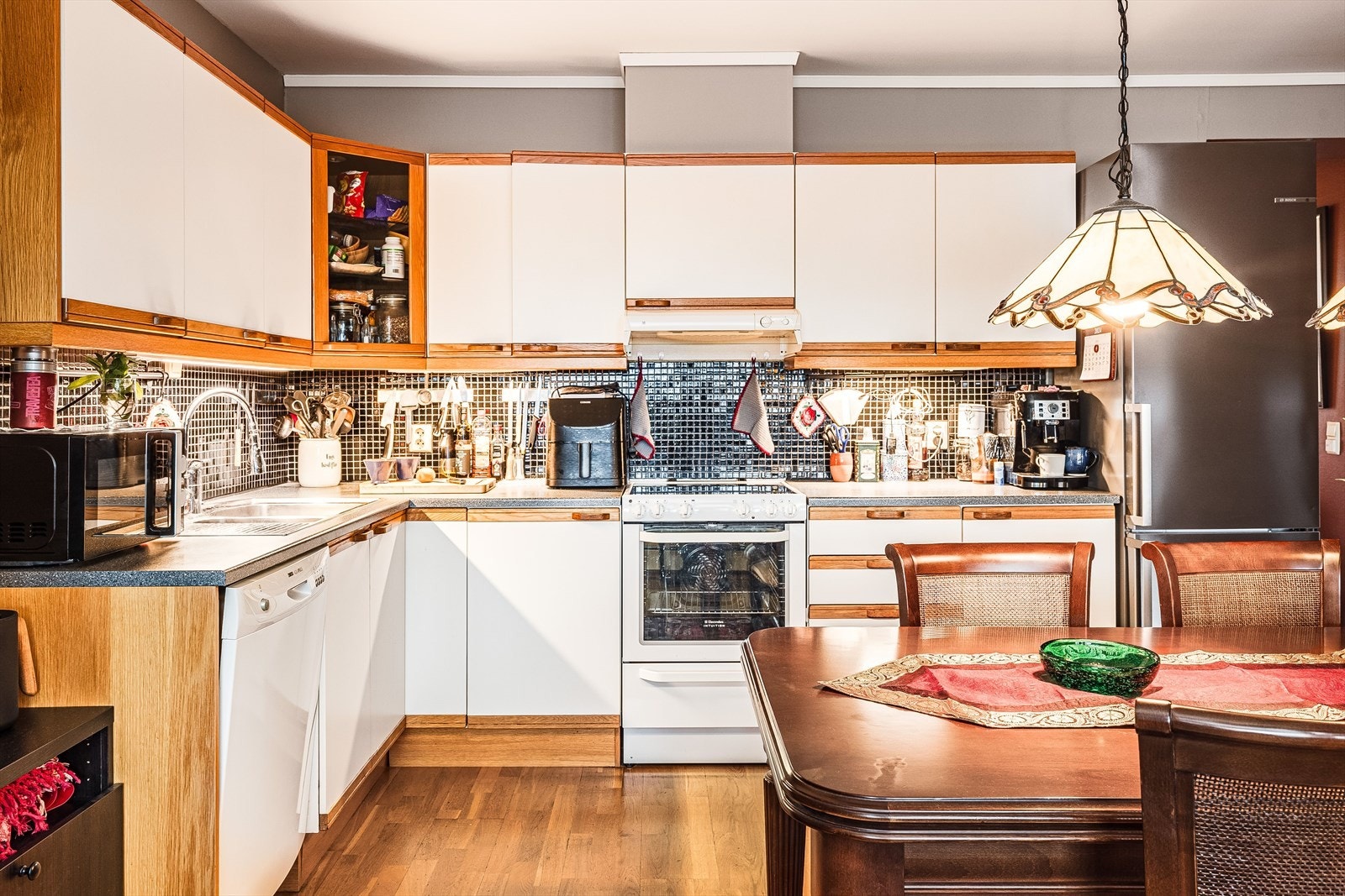 Praktisk med mørke mosaikkfliser i benkeryggen. Det er i nyere tid byttet til LED-belysning under overskapene. Galleribilde