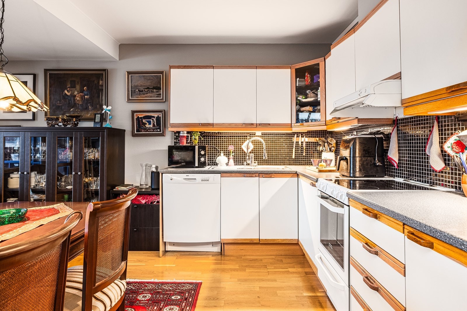 Lys og tidløs kjøkkeninnredning fra 2000 med god skap- og benkeplass. Innredningen har hvite glatte fronter og laminert benkeplate med nedfelt oppvaskkum. Galleribilde