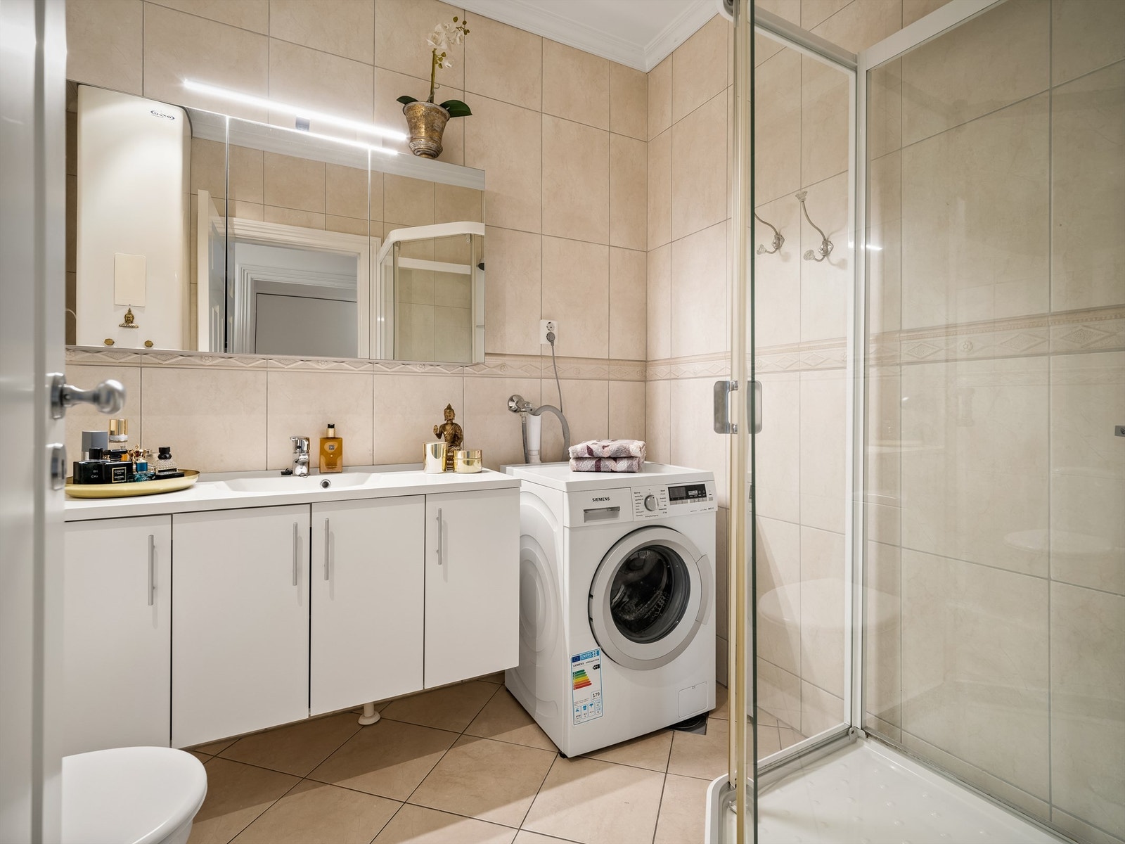 Fliser i like nyanser fremmer helhet på badet. Galleribilde