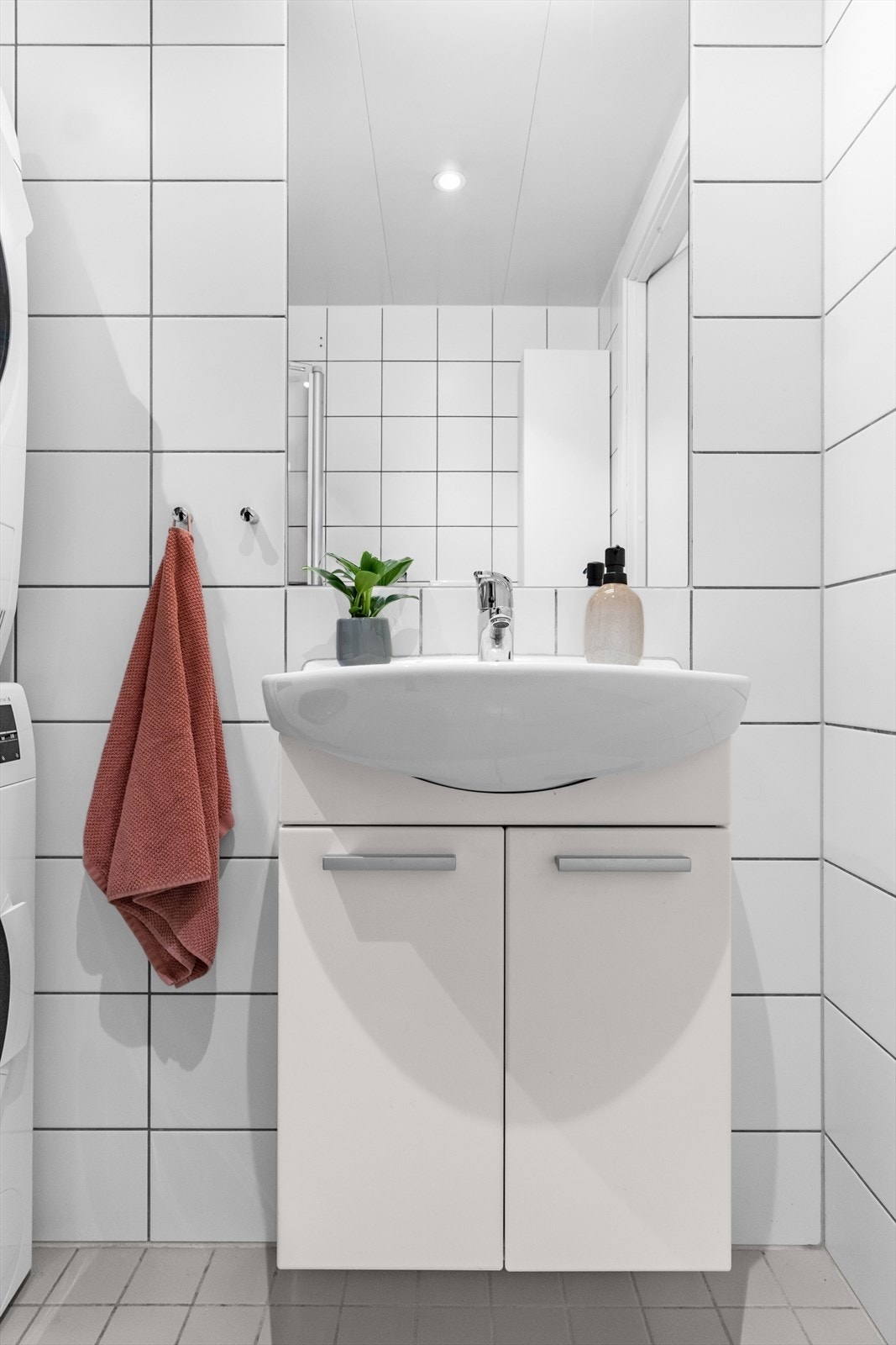 Rommet er innredet med høyskap, servantskap, speil, vegghengt toalett og dusjhjørne med glassdører Galleribilde