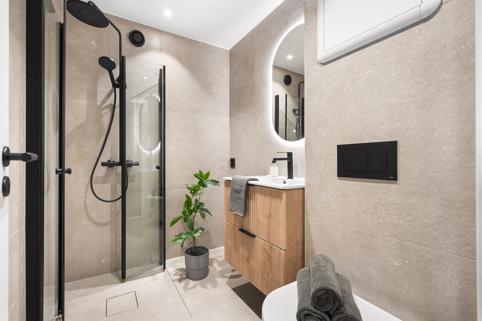 Rålekkert bad pusset opp i 2024 med flislagte overflater, elektrisk gulvvarme og downlights i himling. Det er opplegg for vaskemaskin. Galleribilde