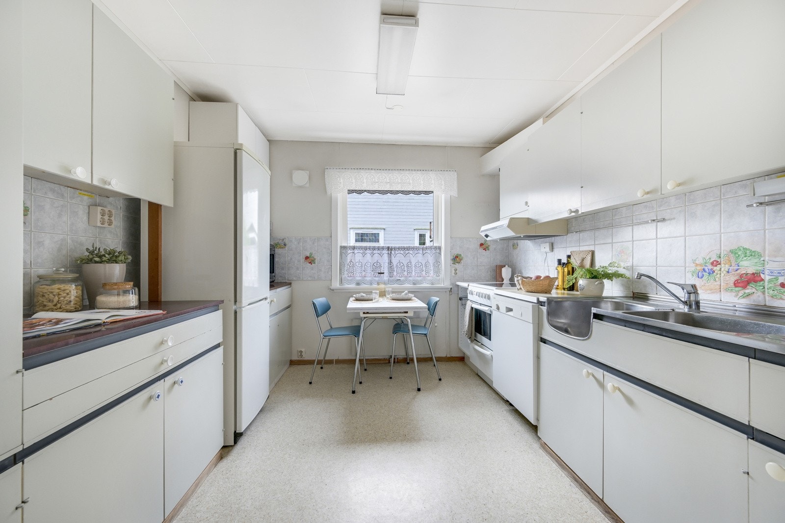 Stort kjøkken med belegg på gulvet, lysmalte vinduer og lysmalt himling. Galleribilde