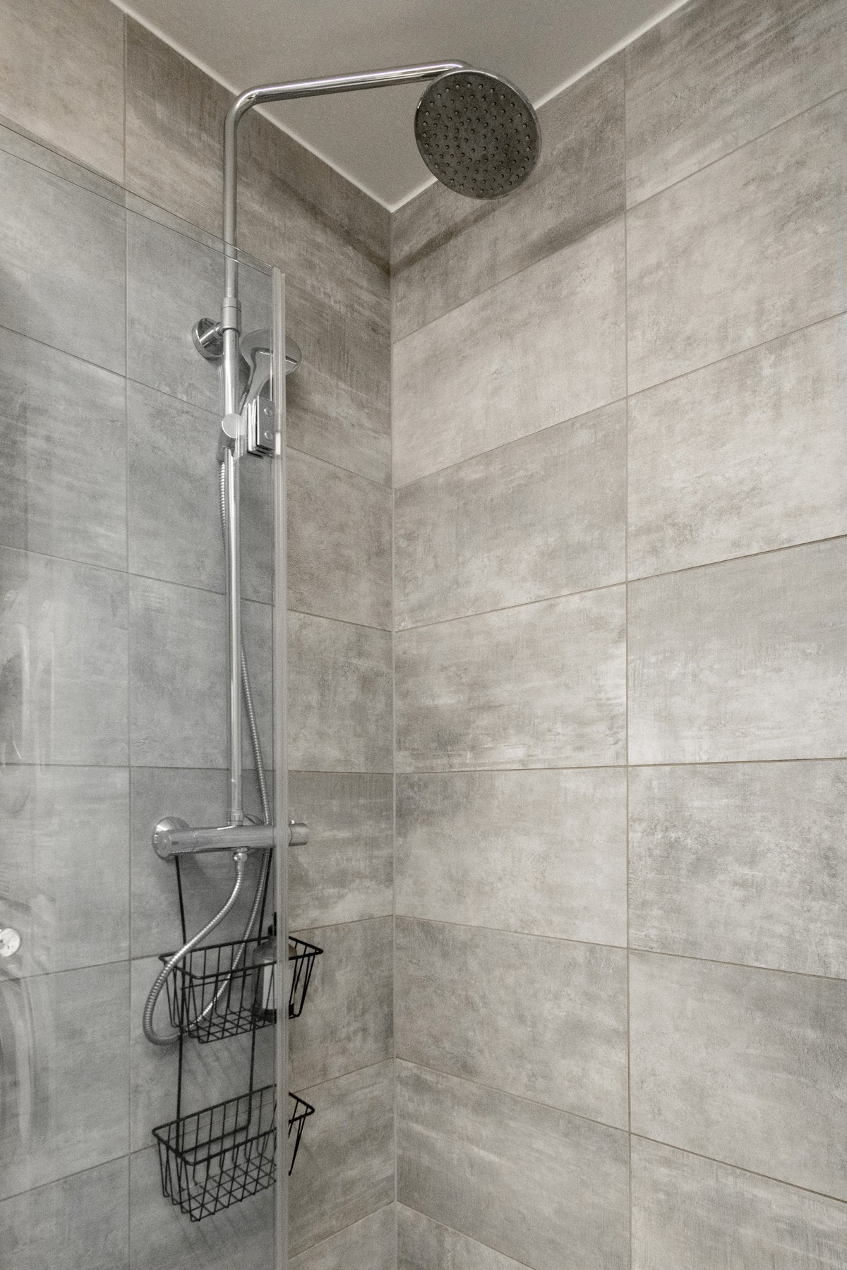 Badet utstyrt med dusjsone bestående av et praktisk dusjhjørne med innfellbare glassdører, hånddusj og en regndusj, samt vegghengt toalett med innebygd sisternekasse. Galleribilde