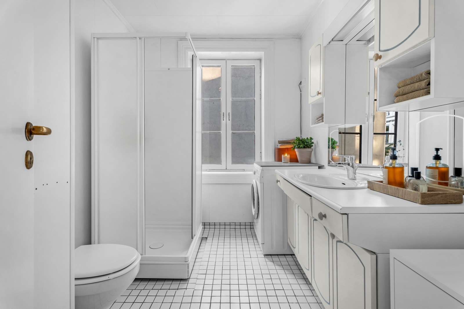 Lyst og romslig bad med flislagt gulv med gulvvarme og malte baderomsplater. Galleribilde