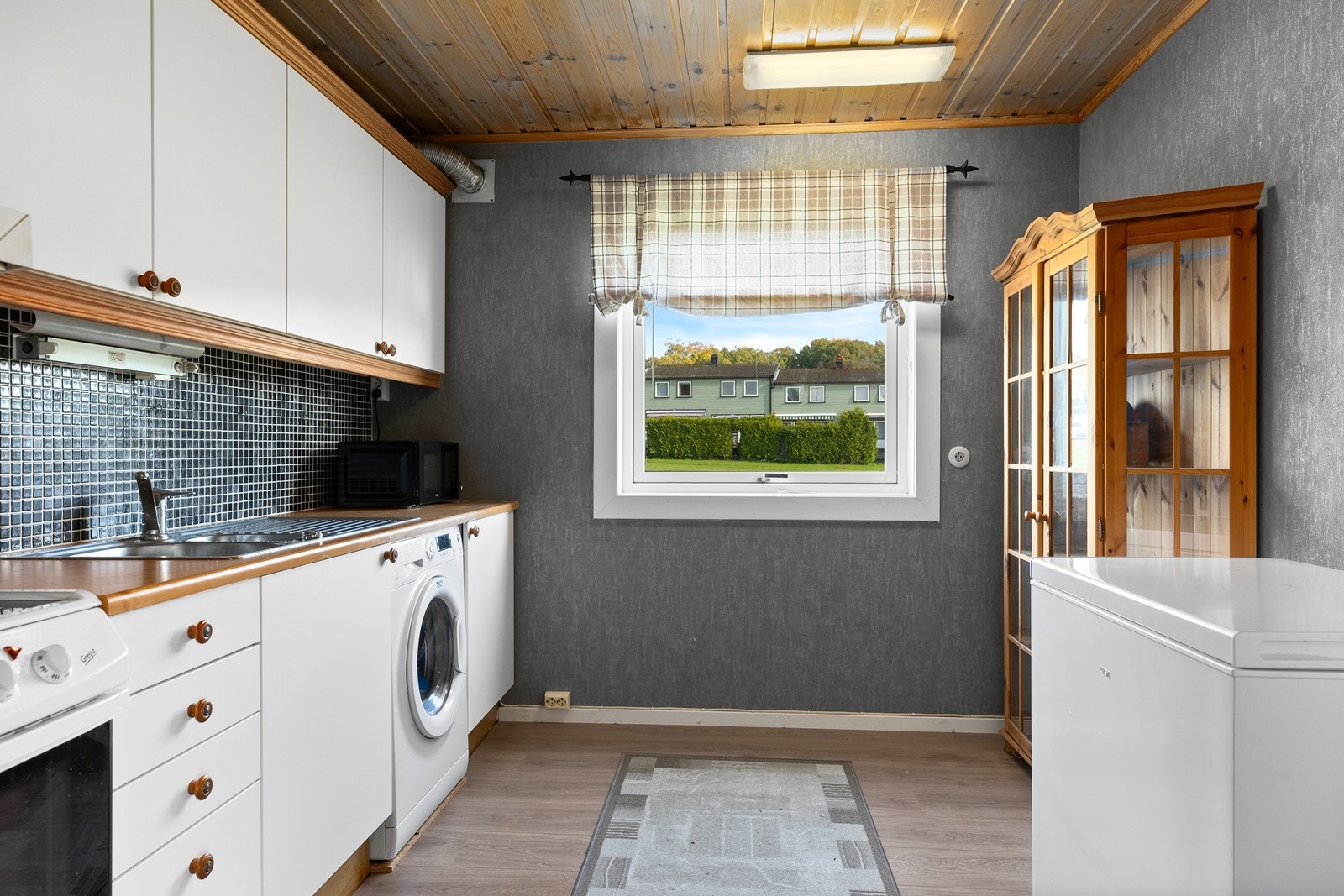 Kjøkkeninnredningen er fra rundt 2005 og har folierte slette fronter og laminat benkeplate Galleribilde