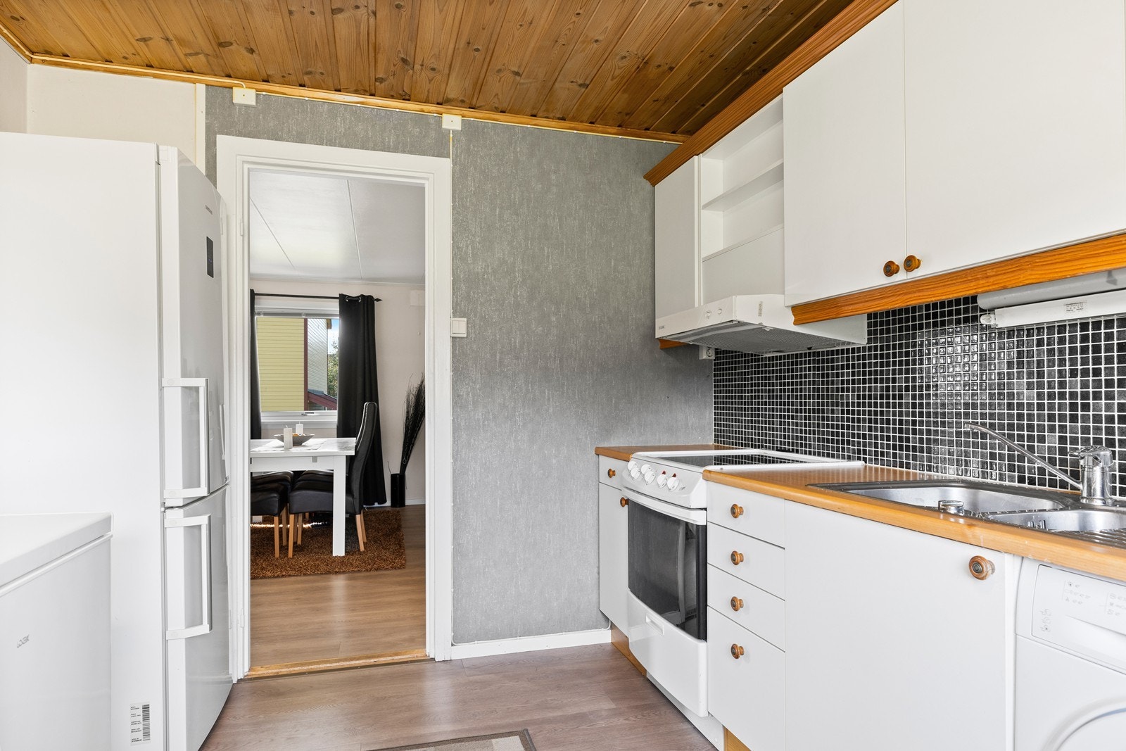 Det er fliser over benk og kjøkkenventilator med avtrekk ut Galleribilde