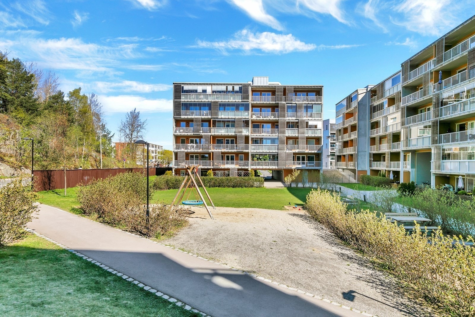 Hyggelig opparbeidet uteområde med sitteplasser og lekeplass Galleribilde