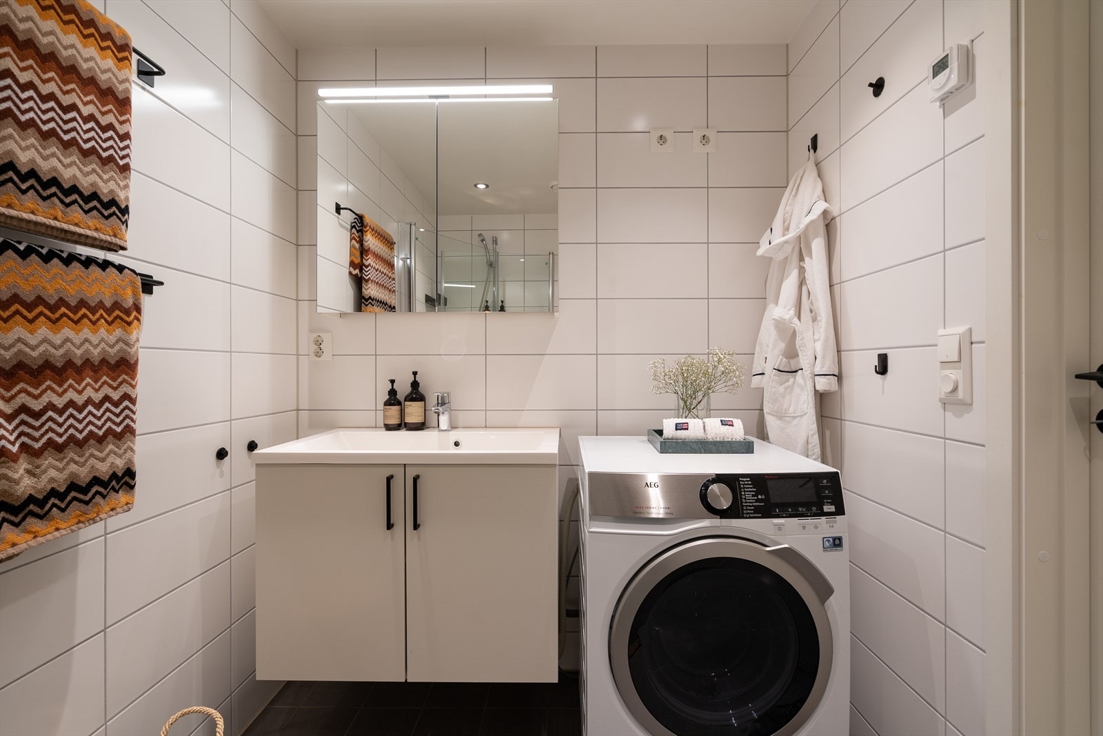 Det er opplegg for vaskemaskin. Det er gulvvarme og downlights i taket som gir behagelig atmosfære under morgen- og kveldsstellet. Galleribilde