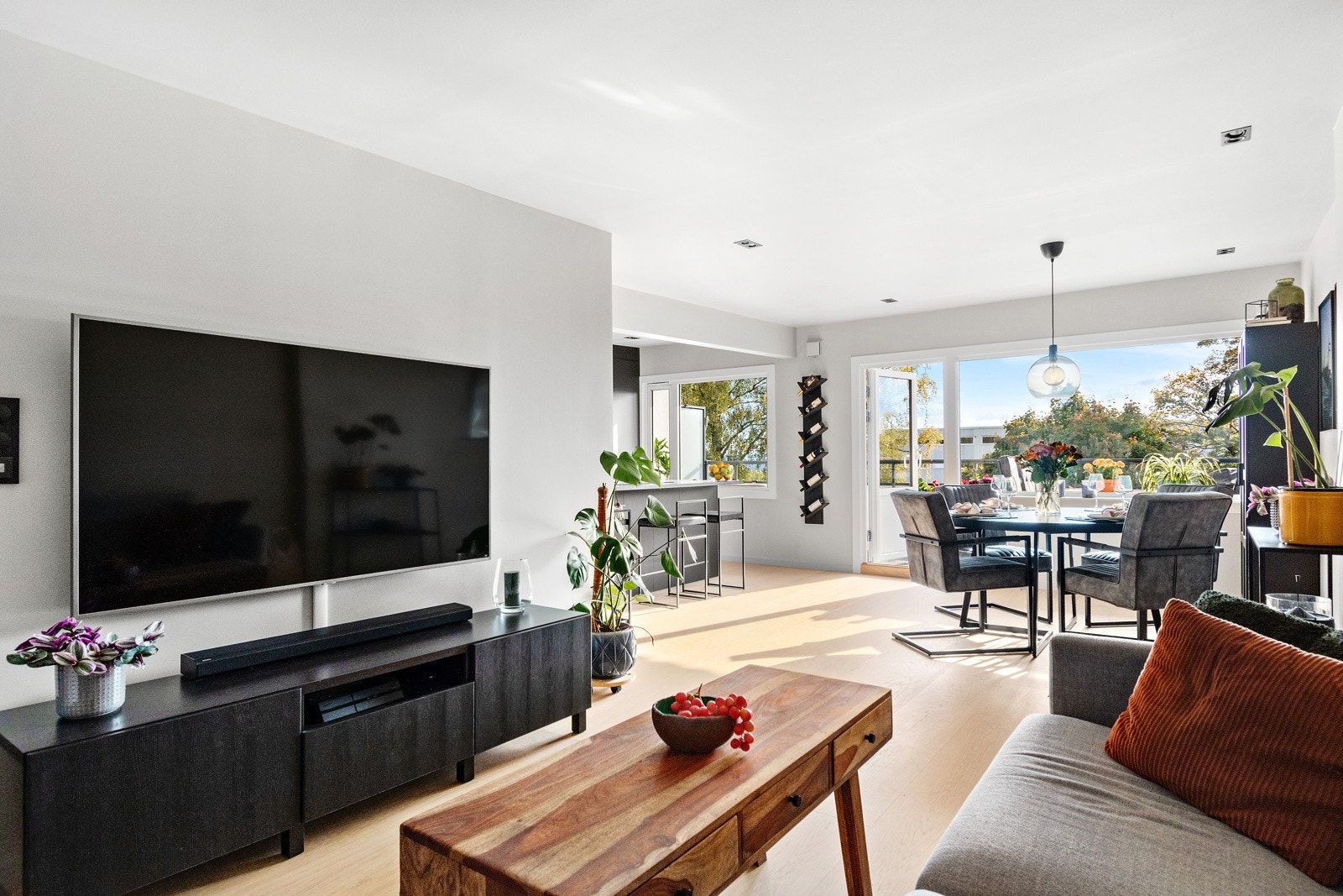 Leiligheten har en åpen løsning men naturlig inndelte soner for TV-stue, spisestue og kjøkken Galleribilde