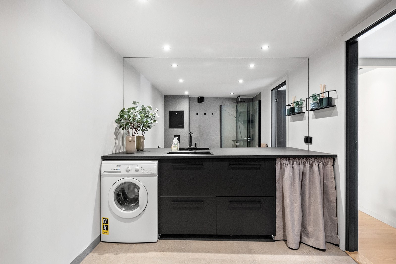 Badet har skap langs hele veggen, noe som gir god oppbevaringsplass og benkplass, samt et stilrent uttrykk. Legg også merke til speilet som er tilpasset rommet Galleribilde