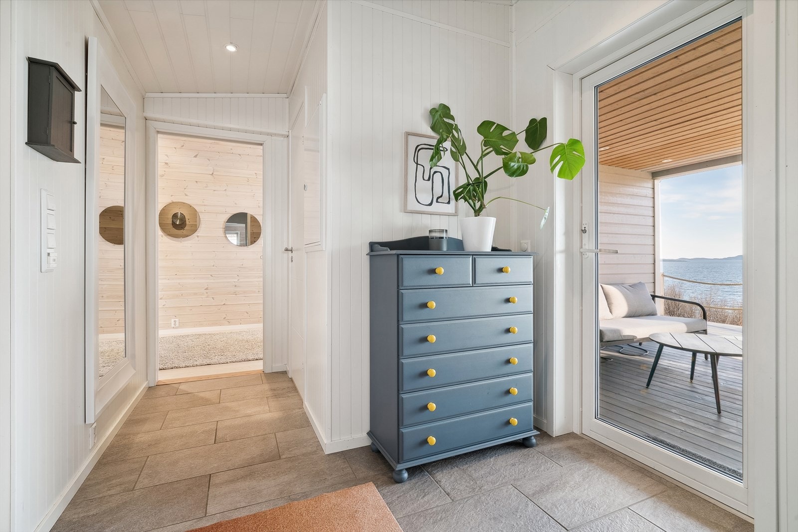 Entré med fliser på gulv og varmekabler. Dør rett ut til terrassen fra dette området. Galleribilde