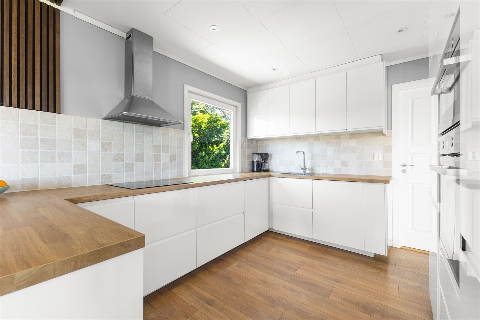 Kjøkkenet er med lyse slette fronter og benkeplate i laminat. Galleribilde