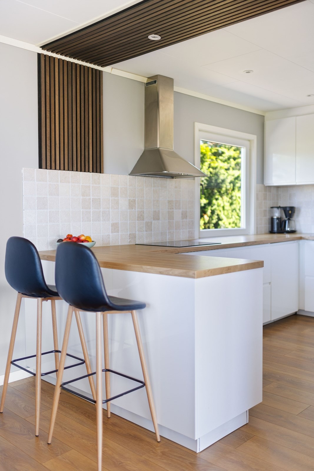 Spiseplassen og kjøkkenet er delt opp med kjøkkenøy som gir enda mer skapplass og barløsning. Galleribilde