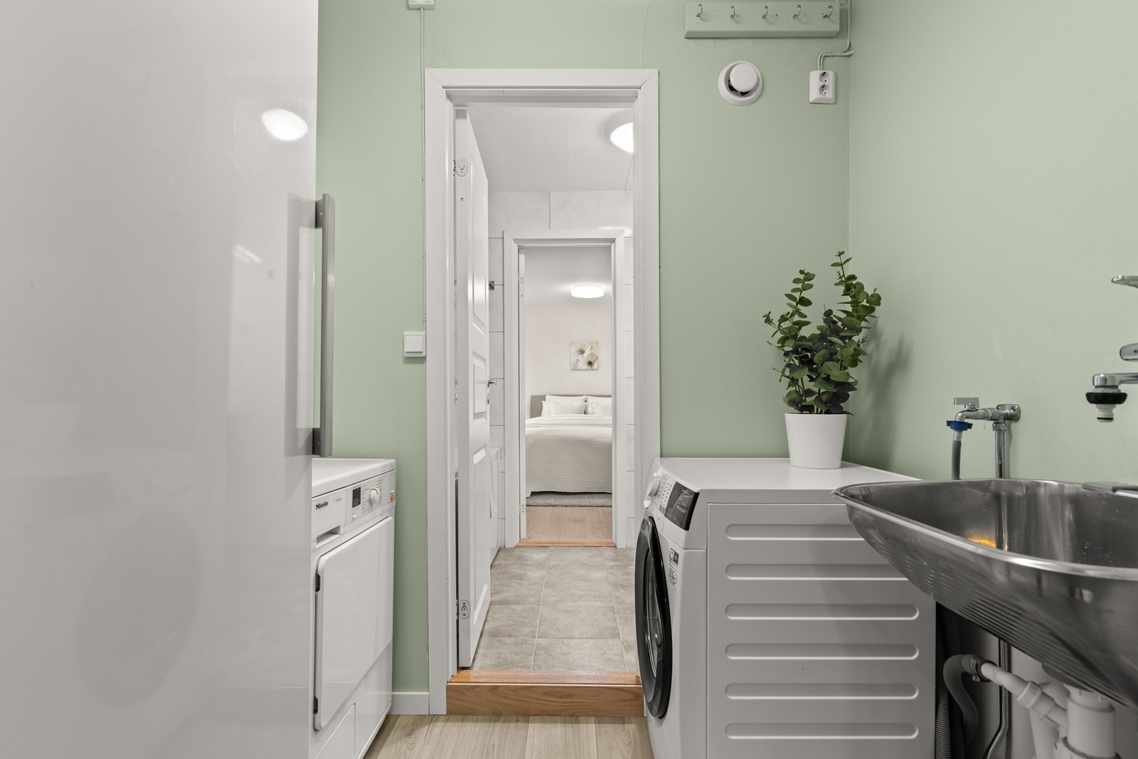 Praktisk separat vaskerom i tilknytning til hovedbadet. Rommet har god plass til både behandling og oppbevaring av tøy. Galleribilde