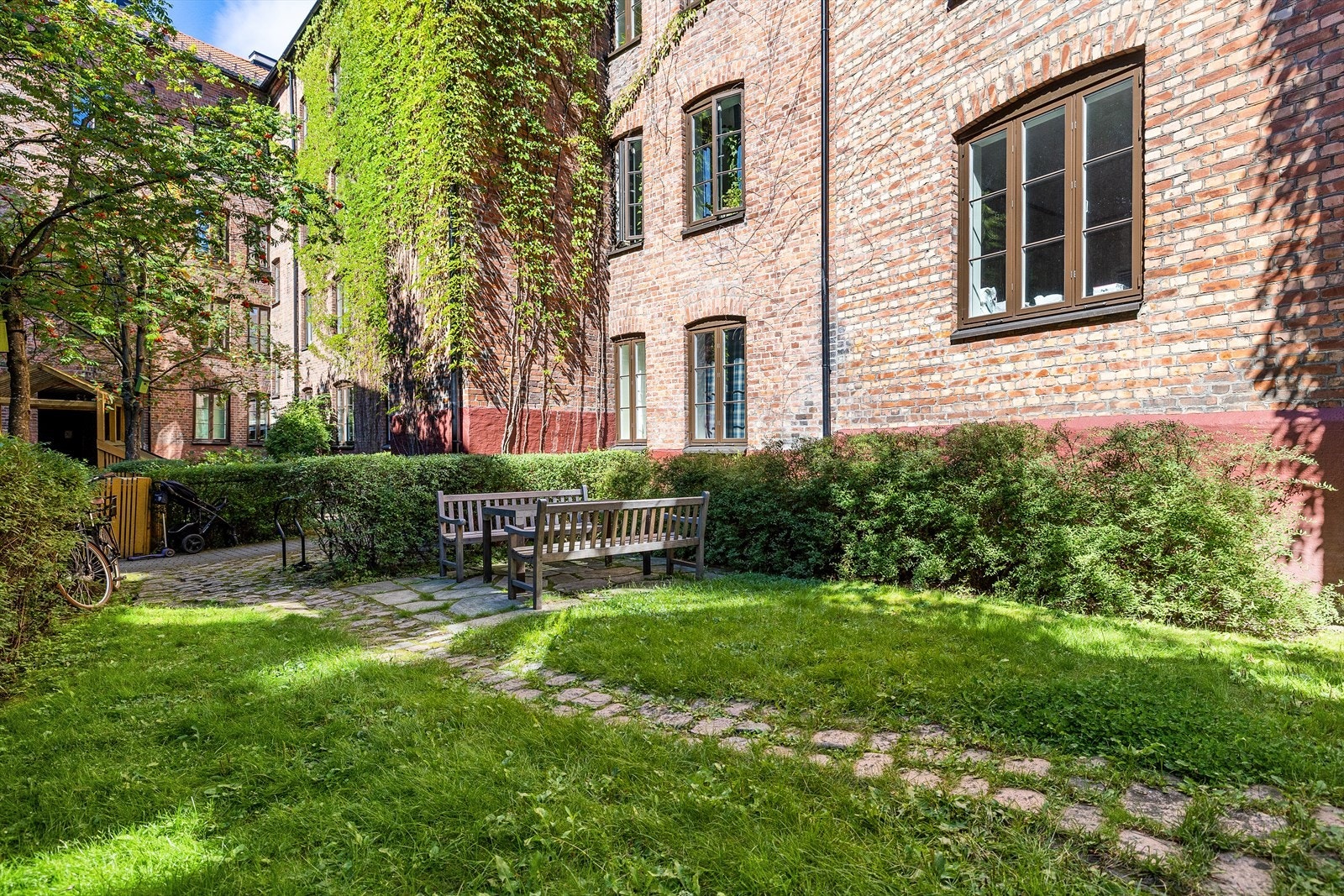 Bakgården er pent opparbeidet med plen og beplantning Galleribilde