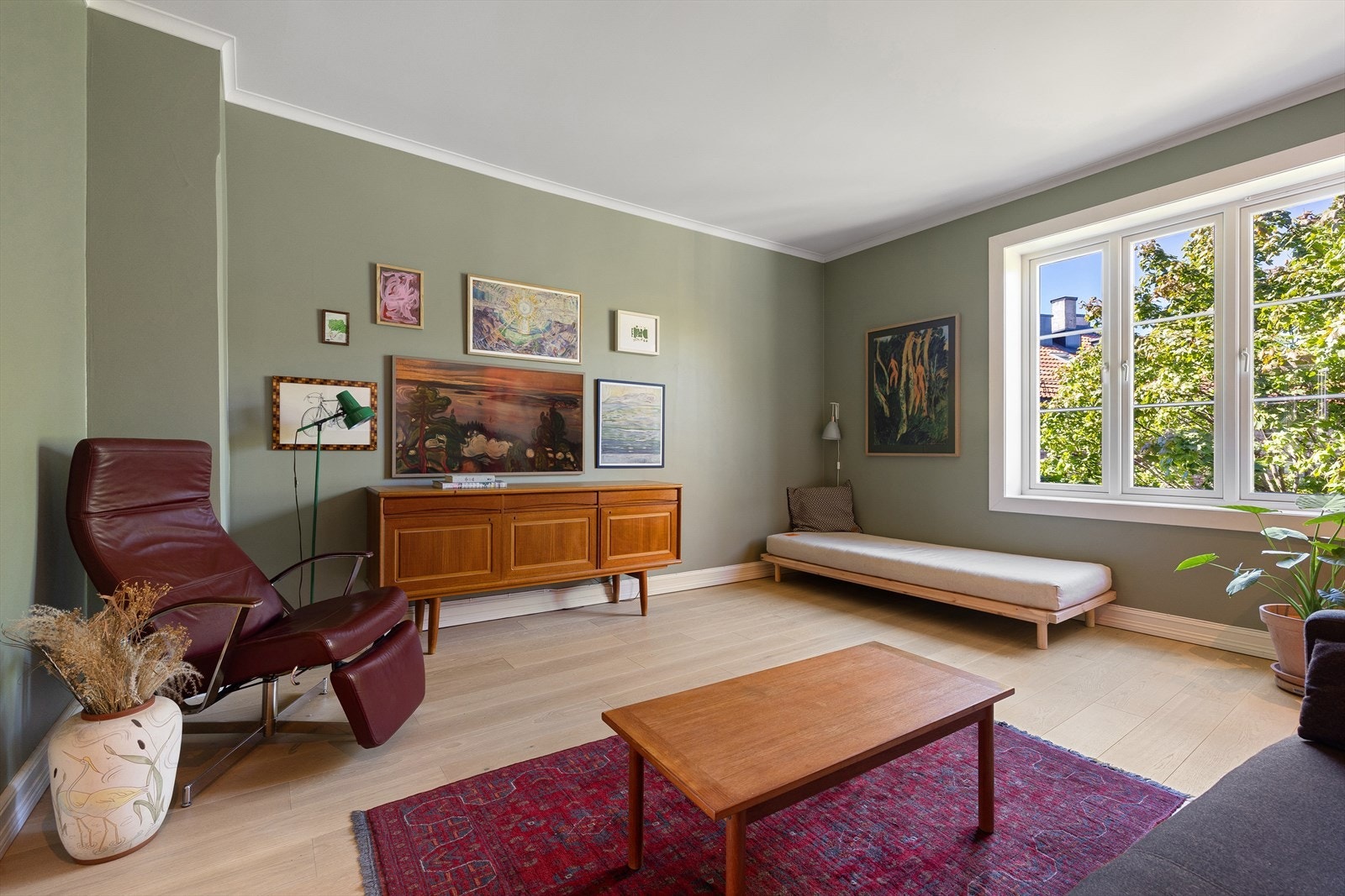 Stuen har store vindusflater med grønt og fint utsyn Galleribilde