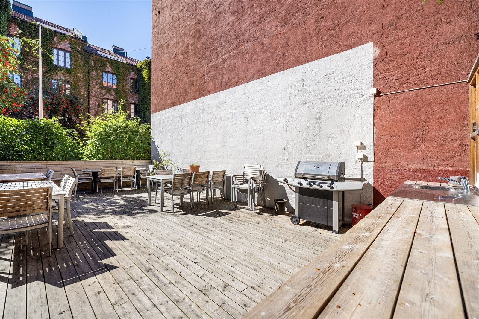 Nyere terrasse i bakgården med utekjøkken og flere sittegrupper Galleribilde