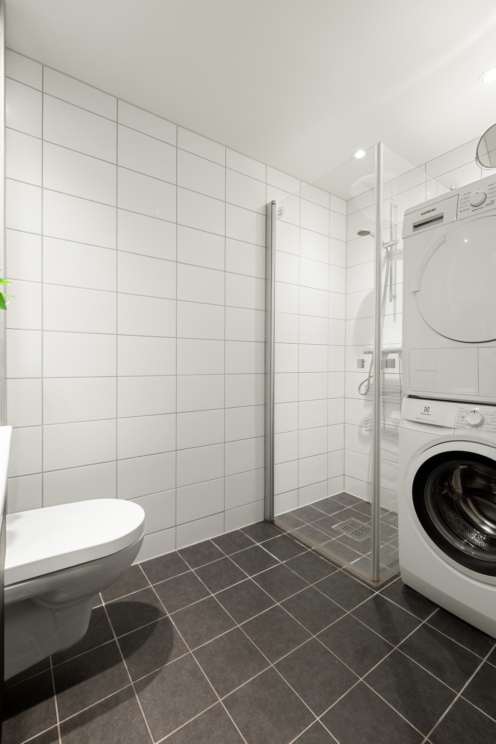 Badet er innredet med dusjhjørne, plass og opplegg for vaskesøyle, vegghengt toalett og servantskap. Galleribilde