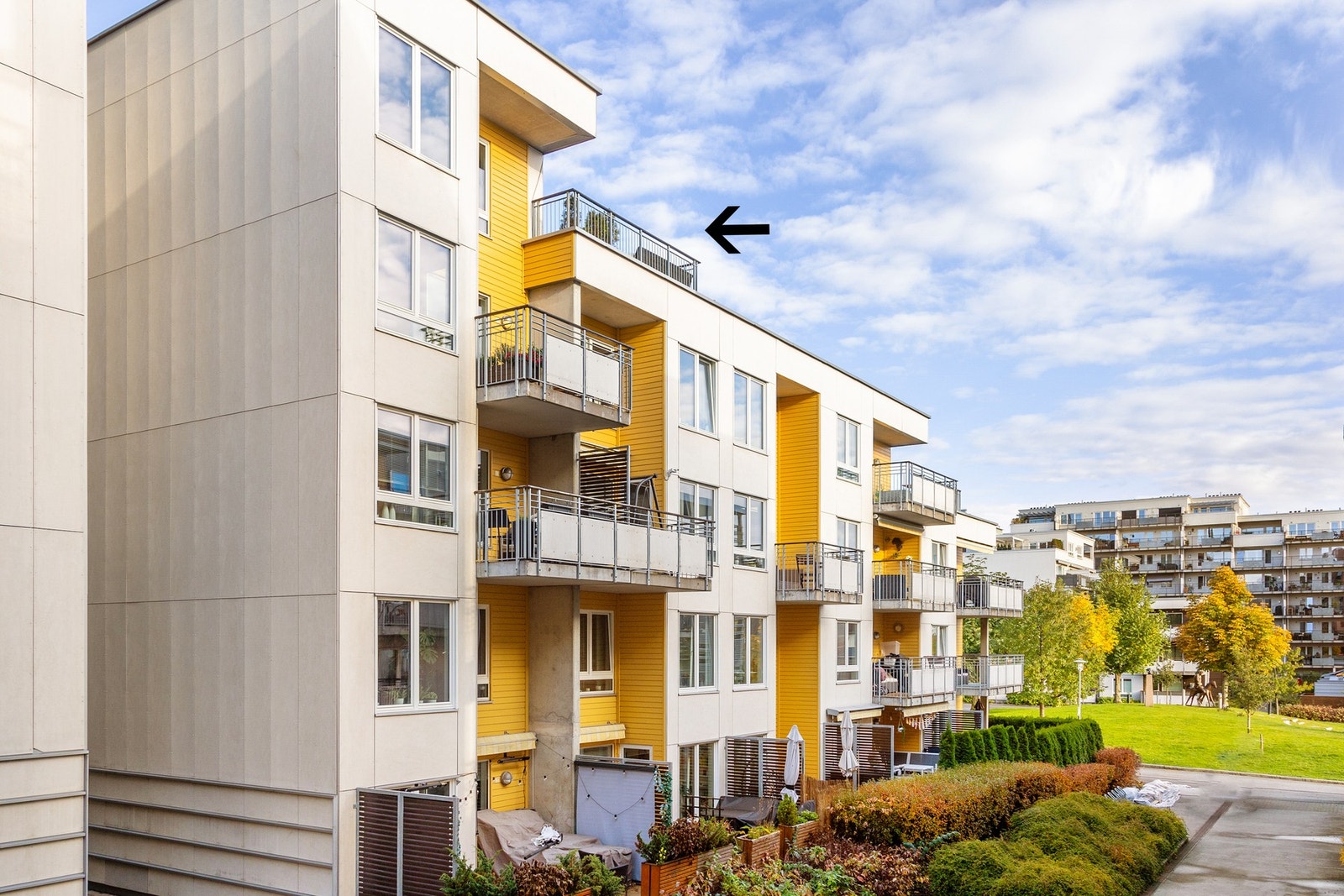 Barnevennlig og fin beliggenhet i rolige omgivelser. Sort pil markerer leilighetens takterrasse. Galleribilde
