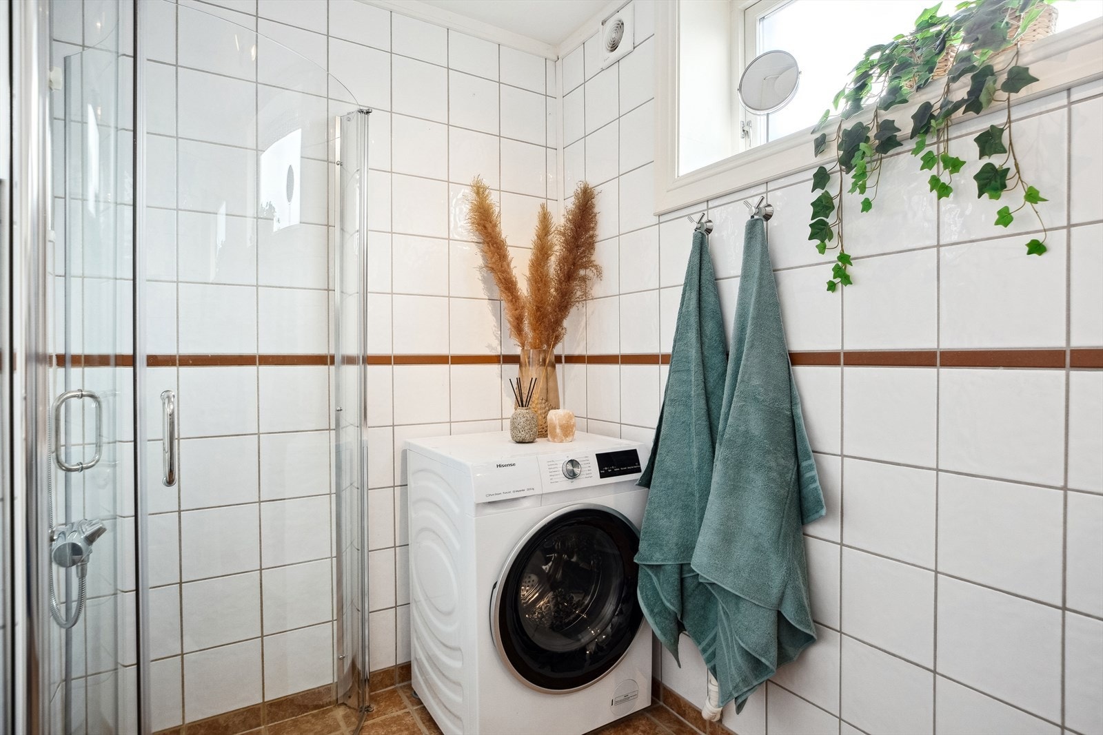 Badet har dusjhjørne og opplegg til vaskemaskin. Galleribilde