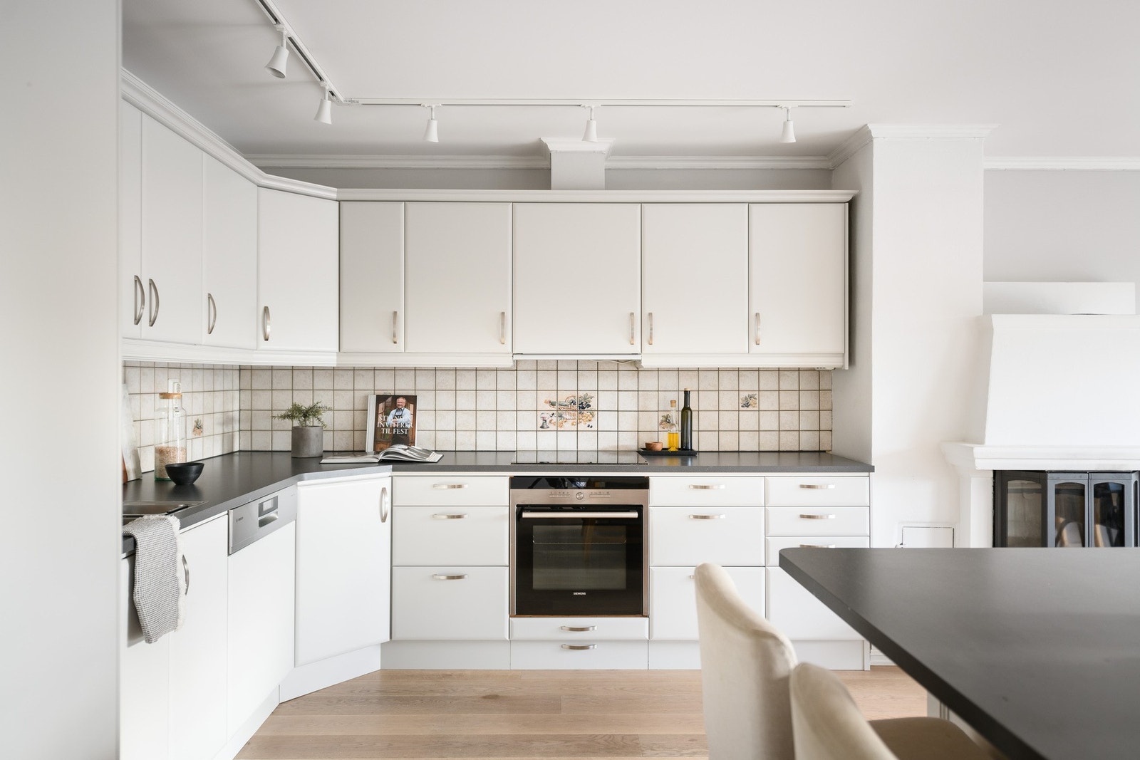 Veggene over benken er kledd med lyse fliser, og under overskapene er det montert god arbeidsbelysning. Galleribilde