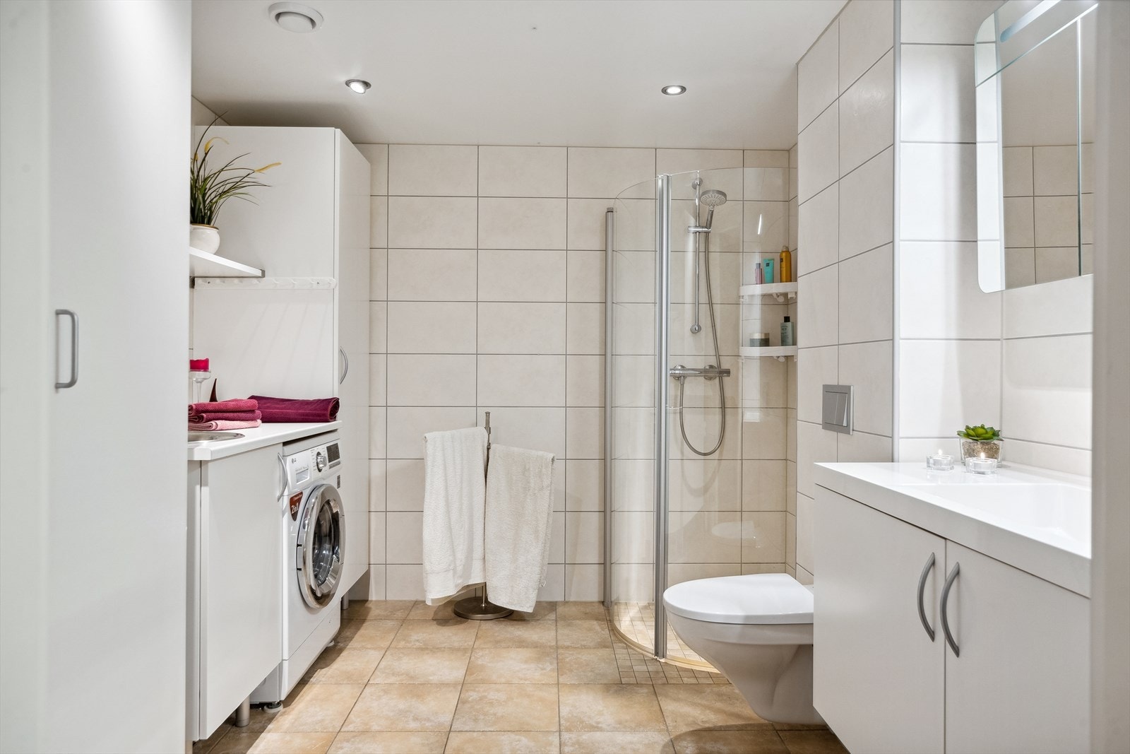 Badet er romlig og delikat med flislagte overflater, downlights og gulvvarme. Galleribilde