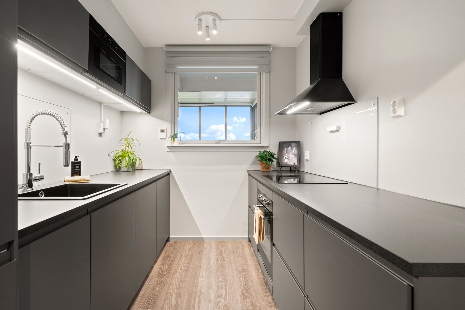 Moderne kjøkken med integrert stekeovn, platetopp, mikroovn, kjøl/fryseskap og oppvaskmaskin. Galleribilde